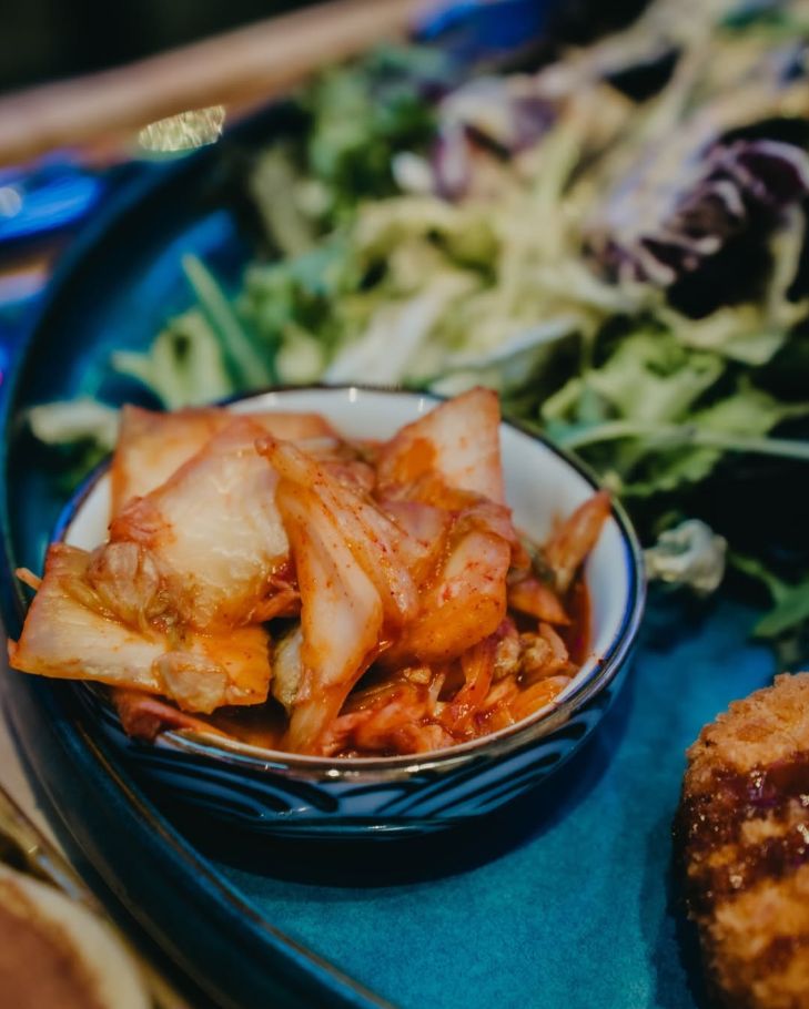 Cuenco de kimchi con ensalada y pollo frito